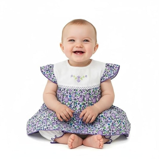 Baby wearing a floral dress with ruffled sleeves on a white background
