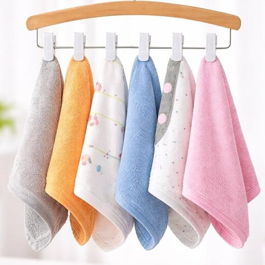 Set of colorful baby towels hanging on a wooden hanger against a white background