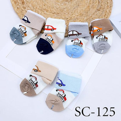 Set of colorful children's socks with vehicle designs on a white surface.