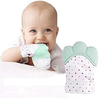 Baby holding a green teething toy with polka dots on a white background