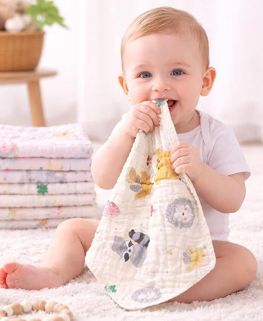 Baby holding a soft toy with animal prints in a bright room.