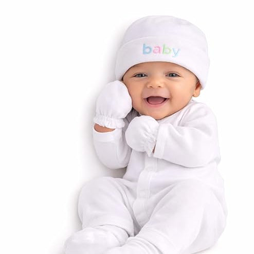 Baby in a white outfit with 'baby' hat on a white background