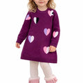 Child wearing a purple sweater with heart patterns and pink boots on a white background