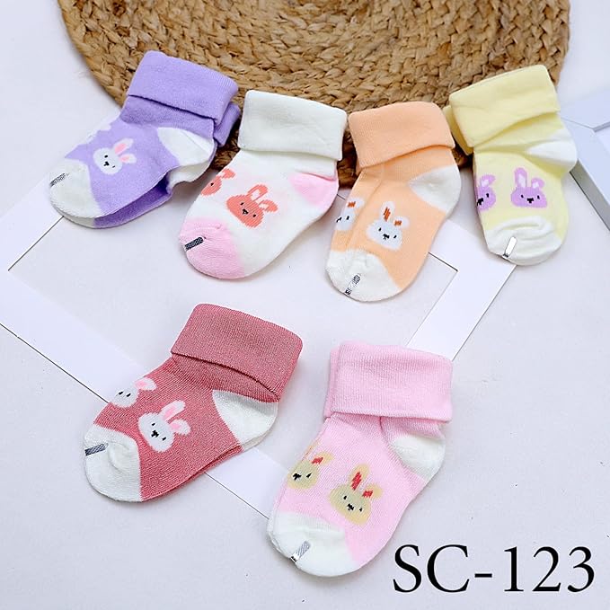 Set of colorful baby socks with cartoon designs on a white surface.