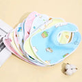 Set of colorful baby bibs with cartoon designs on a beige background