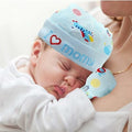 Newborn baby wearing a colorful 'I love mommy' hat and matching blanket.