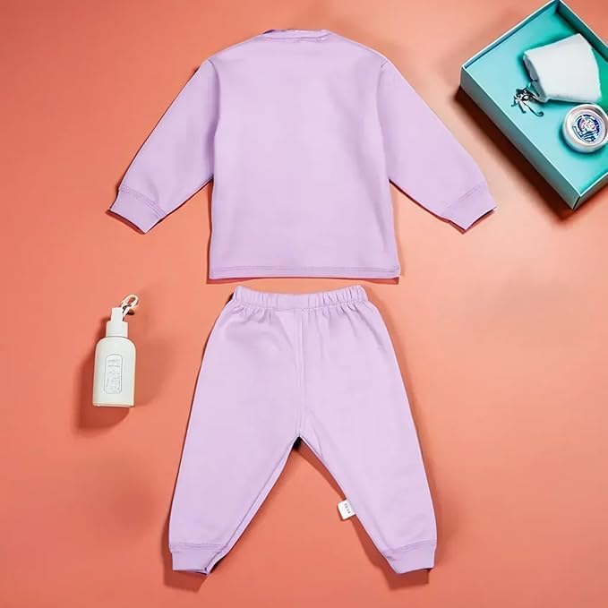 Purple baby outfit with a bottle and box on a peach background