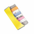 Set of colorful baby socks in a yellow holder on a white background