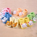 Set of colorful baby socks with animal faces on a beige background