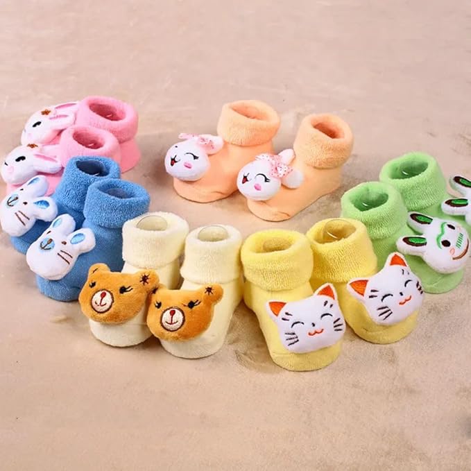 Set of colorful baby socks with animal faces on a beige background