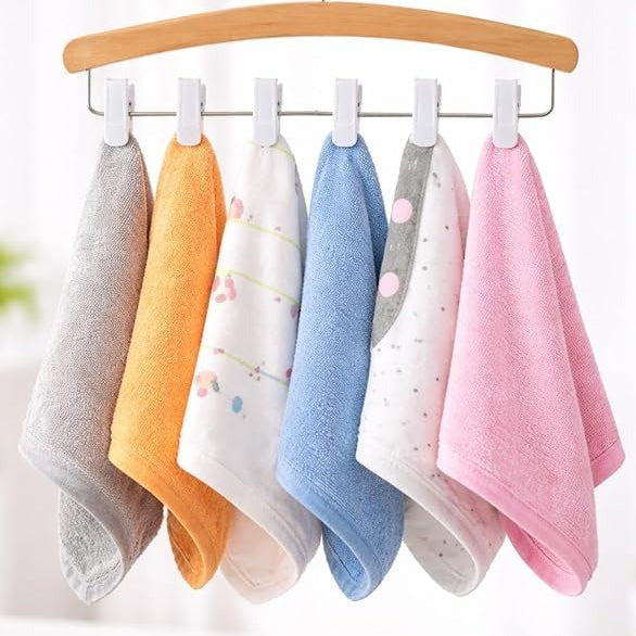 Set of colorful baby towels hanging on a wooden hanger against a white background