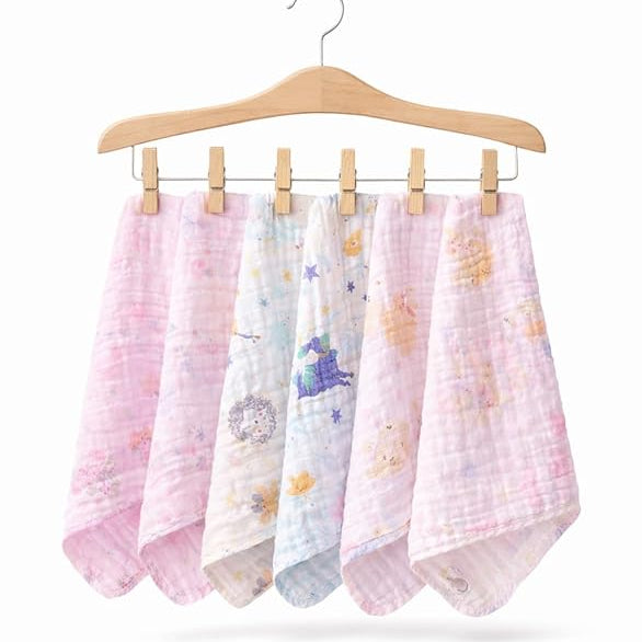 Set of five baby blankets with various patterns hanging on a wooden hanger against a white background.
