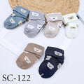 Set of baby socks with bear designs on a white surface