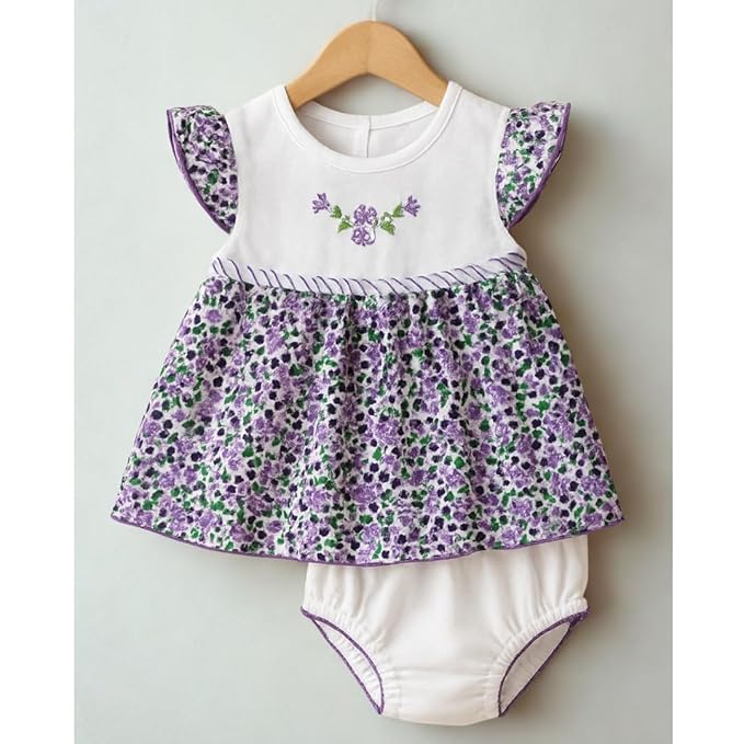 Baby dress with floral pattern and matching bloomers on a hanger against a light gray background