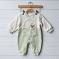 Baby romper with embroidered design on a wooden hanger against a light wooden floor.