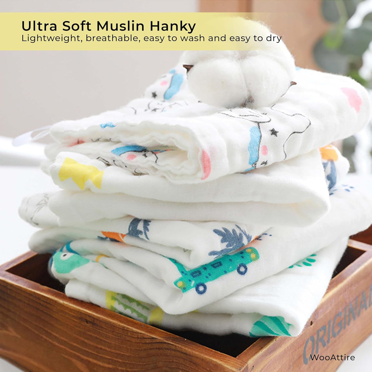 Stack of ultra soft muslin hankies with cartoon prints in a wooden box, labeled 'Ultra Soft Muslin Hanky'.