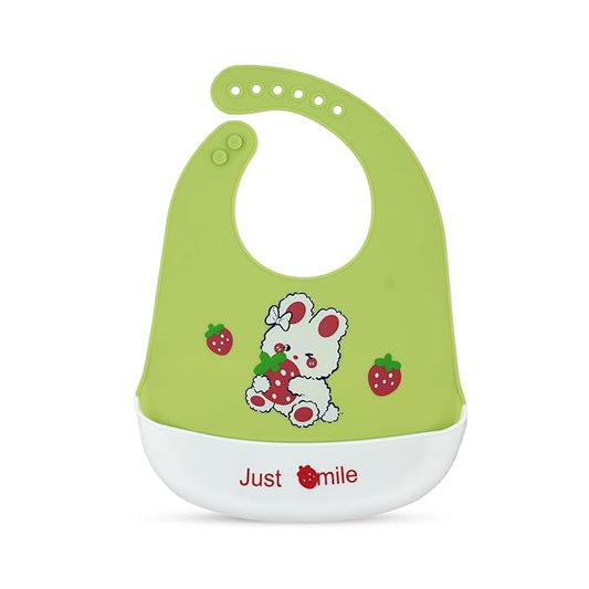 Green baby bib with cartoon design and 'Just Smile' text on a white background