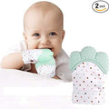 Baby wearing a mint green and white polka dot teething product with another similar product next to it on a white background.